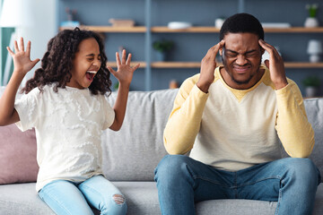 Stubborn noisy african american child girl in screaming at annoyed tired black father, naughty kid...