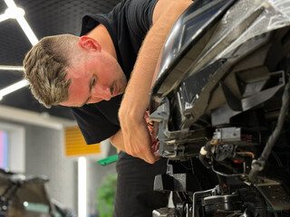 Process of installing a protective polyurethane film for paint on the  headlight of a car. Car...