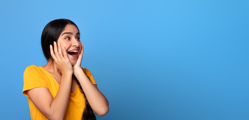 Huge Sale Or Promo Concept. Amazed indian woman screaming and touching her face in disbelief,...
