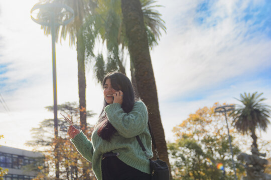 Venezuelan woman in a square talking on the phone happily