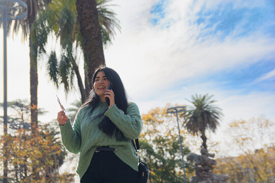 young woman in the square with her cell phone looking in front of her