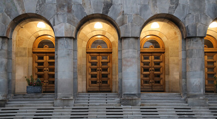 brown wooden Arched european Style Double Doors. Big Double Arch Door in Belgrade Serbia. Stone entrance with granite stairs. Modern style. government building