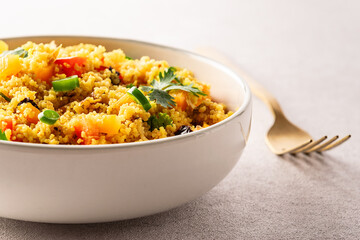 Healthy homemade vegan couscous salad with cilantro, colorful bell peppers pieces, green chilli...