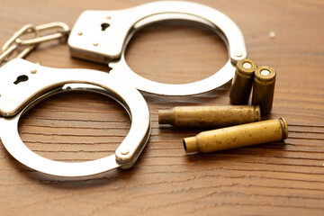 a handcuff in close-up with various bullet casings next to it