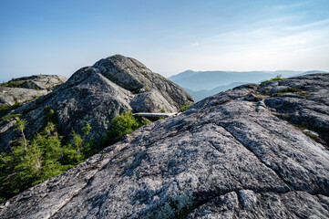 Superb rocky summit of Morios mountain and its small wooden bridge in the Charlevoix region on a warm summer day, Quebec, Canada