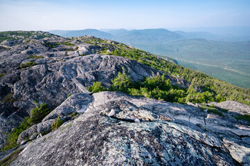 Superb rocky summit of Morios mountain and its small wooden bridge in the Charlevoix region on a warm summer day, Quebec, Canada