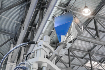 Fototapeta premium Large industrial PVC extrusion machine against industrial metal roof with lighting.