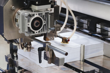 Elements of cardboard boxes are collected in stack. Conveyor line for the production of boxes. Machine cuts cardboard boxes from sheets of cardboard. Enterprise for  production package.