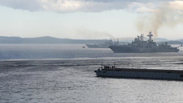 Navy Day. The ship  is sailing in the Kola Bay, putting up a smoke screen. Cloudy cold summer day.