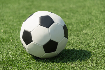 Fototapeta premium Soccer Ball on green grass field. Football stadium background. Summer.