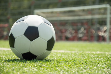 Soccer ball on green grass field before football gate. Soccer ball on field in front of goal post....