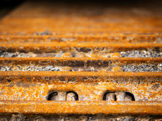 The rusty tracks of a machine are shown in the image. The tracks are old and worn, and the machine is likely a tractor or excavator. Heavy machinery equipment and tools.