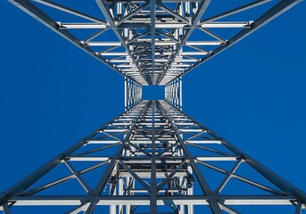 Looking Up at Metal Tower Construction Against Blue Sky