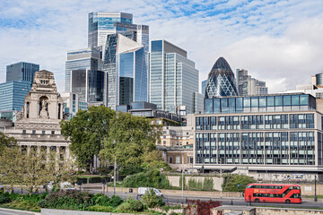 Panoramic view of the city of London business district. London business center skyscrapers with red transport bus. 