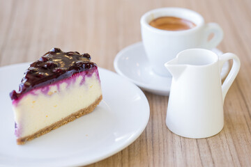 Cup of espresso coffee with a slice of blueberry cheese cake