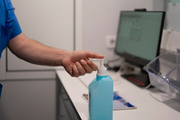 Doctor using hand sanitizer in hospital room