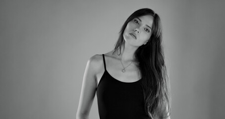 Naklejka premium Studio portrait of a beautiful young woman with long hair wearing a black top and a necklace