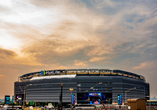 East Rutherford, NJ - US - Jul 26, 2025 MetLife Stadium stands under a dramatic evening sky in East Rutherford, New Jersey, its sleek, metallic facade glowing with signage and lights before an event.