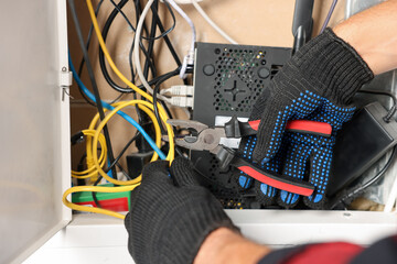 Man fixing heating radiator with pliers indoors, closeup