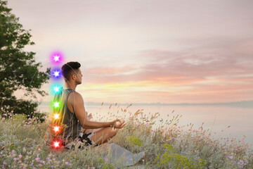 Man meditating in Lotus pose near river. Seven chakras glowing