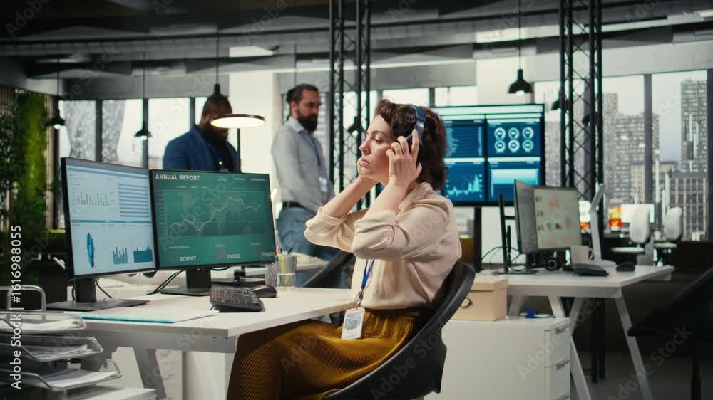 Poster office administrator uses focus music on headset to solve tasks, monitoring performance metrics at t