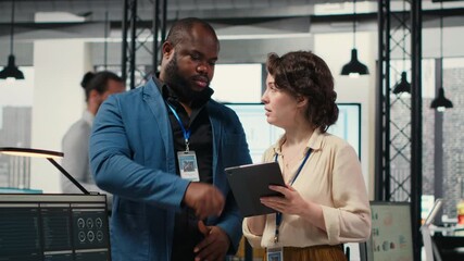 Diverse workers team use digital tools and analytics to improve growth strategy, reviewing financial insights on tablet to foster innovation and development in a modern office environment. Camera B.