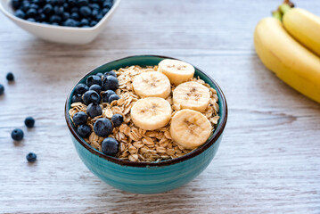 Porridge oatmeal with fresh fruit, a healthy breakfast bowl with oats, banana slices, and...