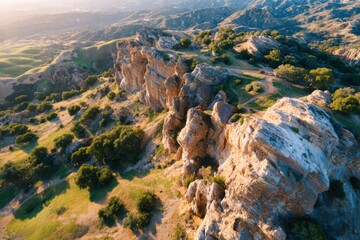 Aerial View of Majestic Rocky Outcrop Surrounded by Lush Greenery and Rolling Hills, Illustrating the Beauty of Nature's Landscape during Golden Hour Light