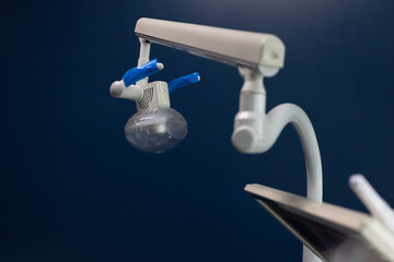 Close-up of a modern dental lamp and part of a screen monitor mounted above a dental chair....
