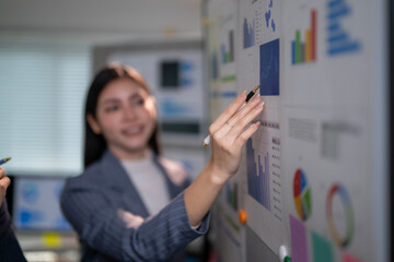 woman pointing at a board with graphs on it