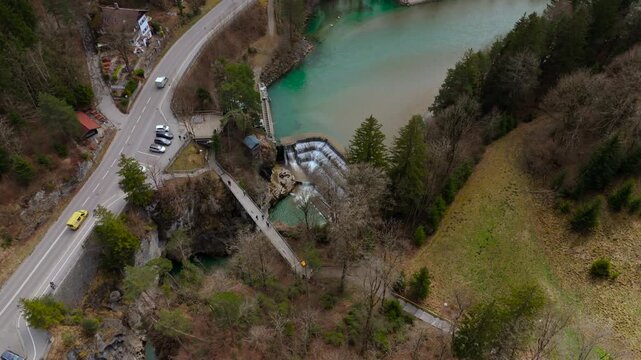 Lechfall, stunning waterfall in Fussen, Bavaria, captured from a high-angle drone shot. The scenic bridge, crystal-clear river, and picturesque landscape make it a perfect travel and photography spot
