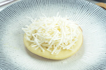 Serabi with grated cheese topping, a traditional Indonesian snack