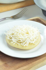 Serabi with grated cheese topping, a traditional Indonesian snack