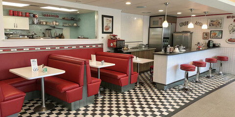 1950s diner-style kitchen with red booth seating and checkered floors.

