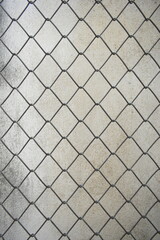 Naklejka premium old wire mesh on dirty wall, construction industry