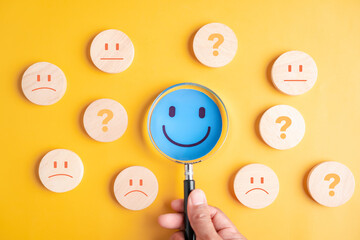 Focus blue smile face among mixed emotions on yellow background, focusing on happiness, mental...