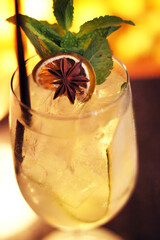 A white cocktail with garnishes in a wine glass.