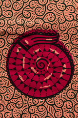 top view of orange ankara fabric, flatlay of peach nigerian wax cloth with designs, spread out...
