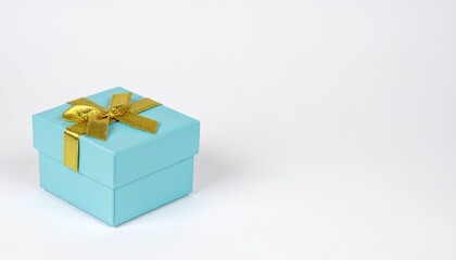 Obraz premium Light Blue Gift Box With Gold Ribbon And Bow On White Surface For Celebration And Giving