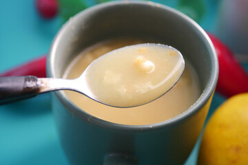 Soup served in a cup with a spoon ready to taste