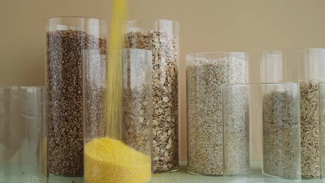 Refillable glass jar with raw grain porridge. Copy space Refill product format eco-friendly living. Filling reusable container Whole spelt grain species. High protein fiber-rich vegan plant based food
