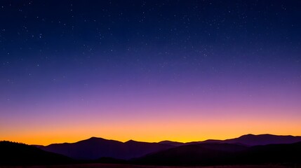 Fototapeta premium Silhouette of mountains against a vibrant sunset sky sprinkled with stars.