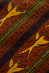 top view of brown ankara fabric, flatlay of nigerian wax cloth with designs, spread out brown...