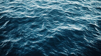 Fototapeta premium A vast expanse of deep blue ocean with gentle waves and a few ripples, reflecting the light from above.