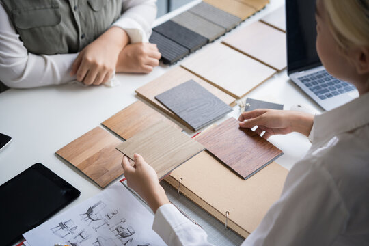 Interior designer presenting eco friendly wooden material samples for sustainable home decor