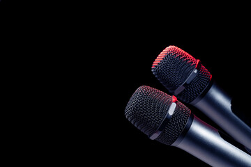 Close-up of microphone in studio or concert performance on stage, on black background.