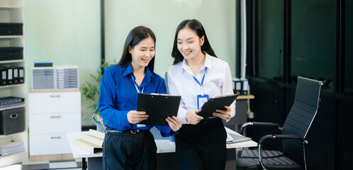 Two Asian businesswoman and man discuss investment project working and planning strategy