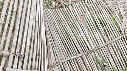 Traditional bamboo fence arranged in a vertical pattern, used for rural and agricultural purposes in Asia.