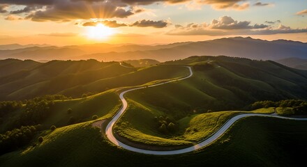 Fototapeta premium Photo of a winding road snakes through lush green hills at a golden sunset