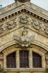 Richly ornate architectural facade of the Opéra Garnier (Palais Garnier) in Paris. The image highlights a beautifully sculpted bust of a classical figure adorned with laurel branches